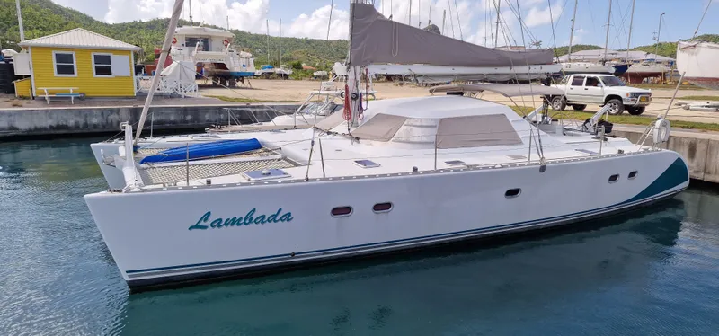 Lambada Yacht Photos Pics 1993 Lagoon 47 catamaran docked in a marina, featuring sleek design and spacious deck.