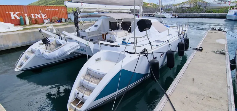 Lambada Yacht Photos Pics Catamaran Lagoon 47, 1993 model, docked at marina with inflatable dinghy.