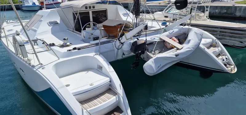 Lambada Yacht Photos Pics Lagoon 47 catamaran from 1993 docked with inflatable dinghy attached.