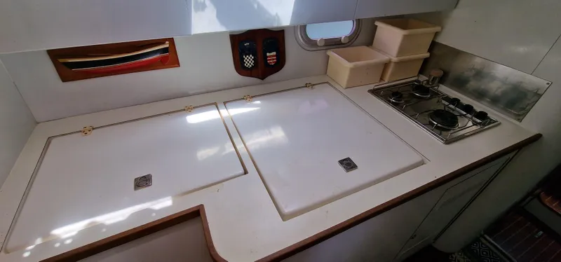 Lambada Yacht Photos Pics Compact kitchen area in a 1993 Lagoon 47 yacht with stove and storage.