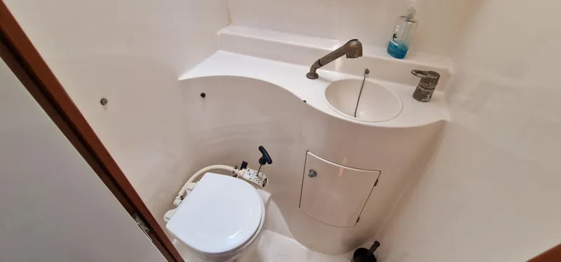 Lambada Yacht Photos Pics Compact bathroom in a 1993 Lagoon 47 yacht with toilet, sink, and faucet.
