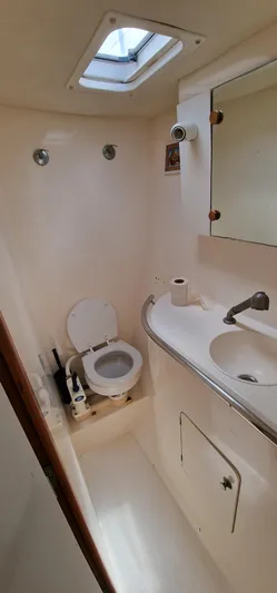 Lambada Yacht Photos Pics Compact bathroom in a 1993 Lagoon 47 yacht with toilet, sink, and mirror.