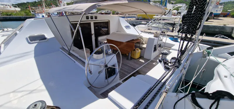 Lambada Yacht Photos Pics Lagoon 47 catamaran from 1993, featuring spacious deck and dual steering wheels at the marina.