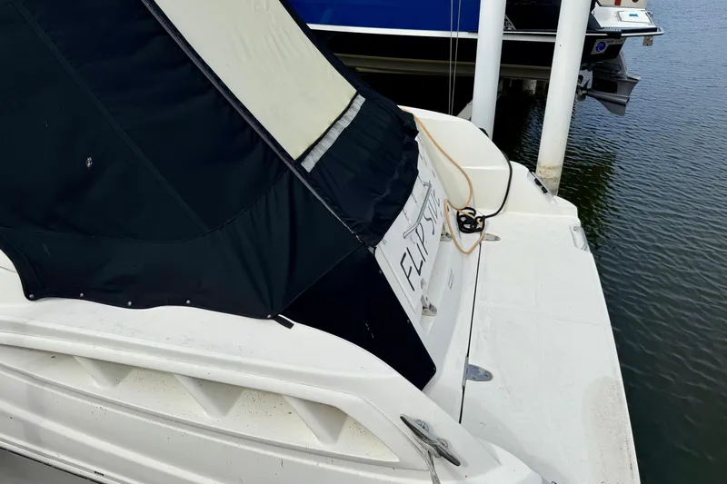 Flip Side Yacht Photos Pics 2010 Sea Ray 330 Sundancer docked, featuring a black canopy and white deck.
