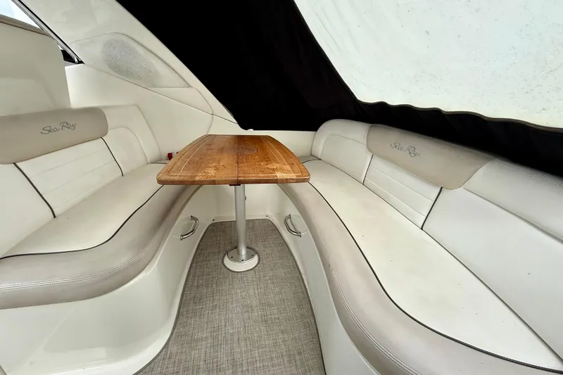 Flip Side Yacht Photos Pics Interior of 2010 Sea Ray 330 Sundancer with white seating and wooden table.