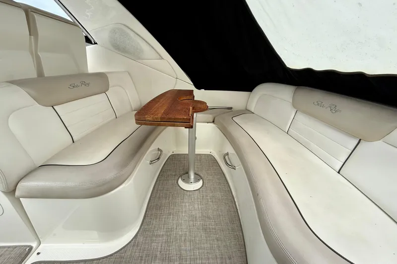 Flip Side Yacht Photos Pics Interior of 2010 Sea Ray 330 Sundancer with beige seating and wooden table.