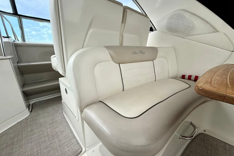 Flip Side Yacht Photos Pics Interior of 2010 Sea Ray 330 Sundancer boat with white seating and wooden table.