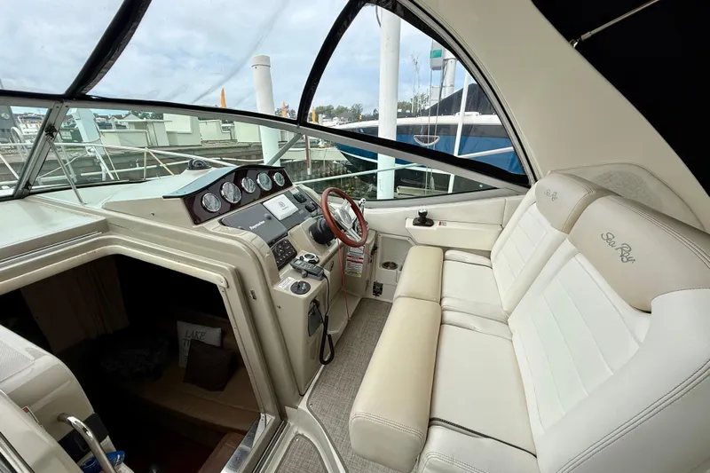 Flip Side Yacht Photos Pics 2010 Sea Ray 330 Sundancer cockpit with beige seating and modern dashboard controls.
