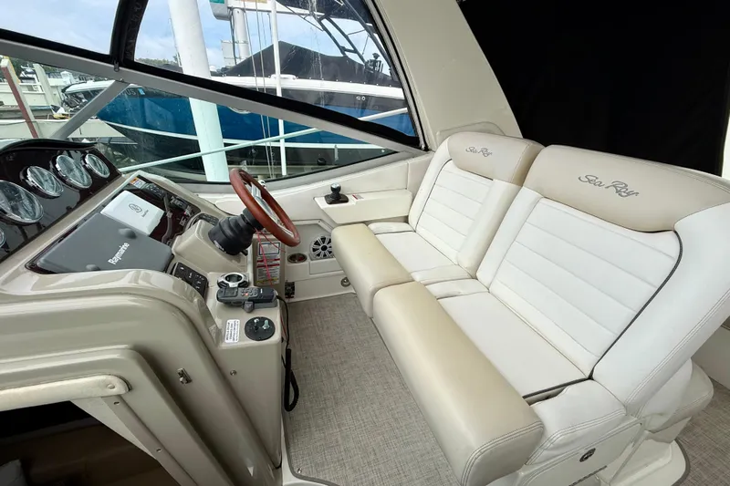 Flip Side Yacht Photos Pics Cockpit of 2010 Sea Ray 330 Sundancer with beige and white seating, steering wheel, and control panel.