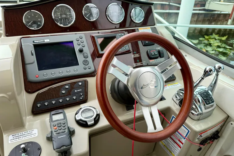 Flip Side Yacht Photos Pics Control panel of a 2010 Sea Ray 330 Sundancer boat with steering wheel and navigation instruments.