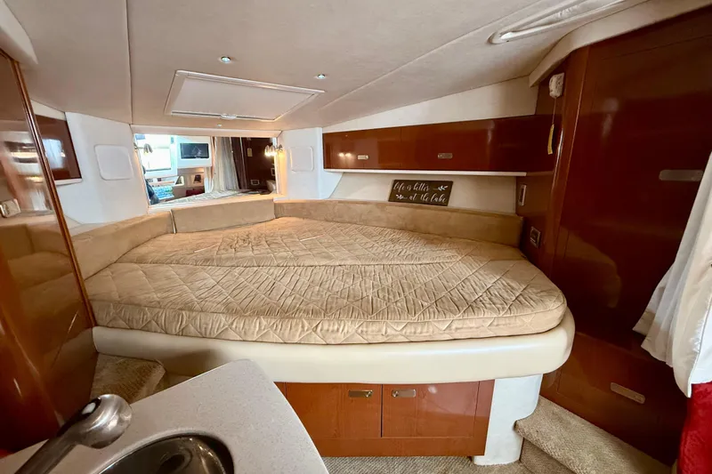 Flip Side Yacht Photos Pics Luxurious interior of 2010 Sea Ray 330 Sundancer yacht with cozy bed and elegant wood finishes.