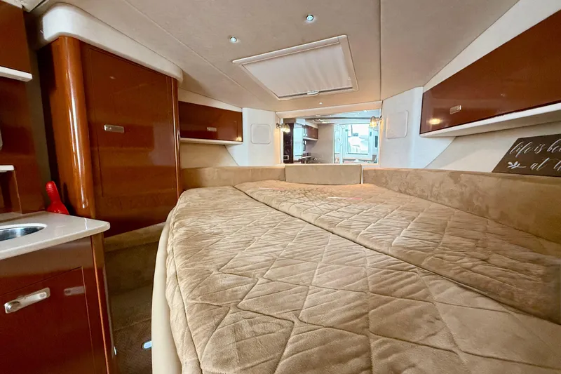 Flip Side Yacht Photos Pics Luxurious interior of 2010 Sea Ray 330 Sundancer with cozy bed and elegant wood finishes.