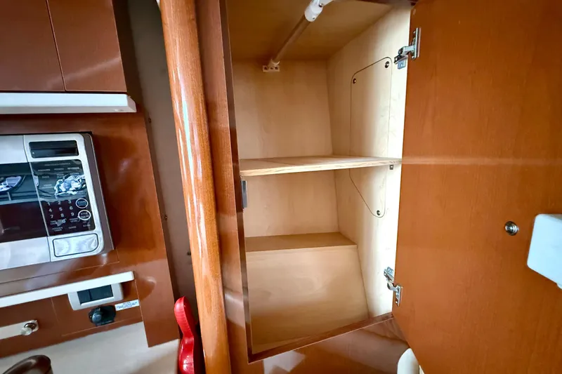 Flip Side Yacht Photos Pics Interior of 2010 Sea Ray 330 Sundancer showing wooden cabinet and microwave.