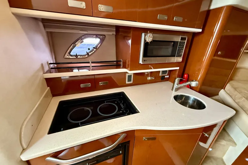 Flip Side Yacht Photos Pics Luxurious 2010 Sea Ray 330 Sundancer yacht kitchen with stove, microwave, and sink.