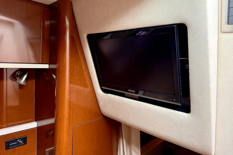 Flip Side Yacht Photos Pics Interior of 2010 Sea Ray 330 Sundancer with wall-mounted TV and wooden cabinetry.