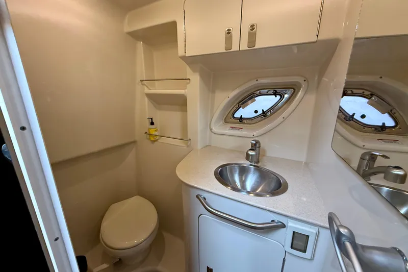 Flip Side Yacht Photos Pics 2010 Sea Ray 330 Sundancer bathroom with sink, toilet, and porthole window.