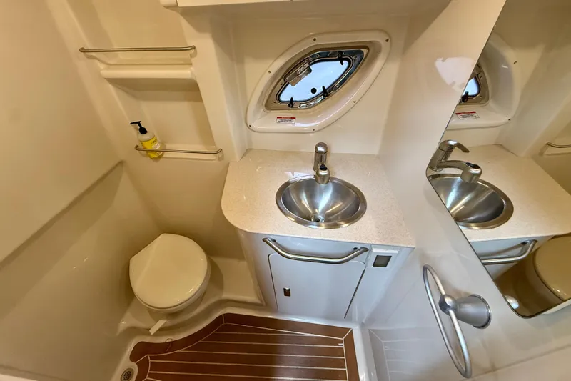 Flip Side Yacht Photos Pics 2010 Sea Ray 330 Sundancer bathroom with sink, toilet, and porthole window.