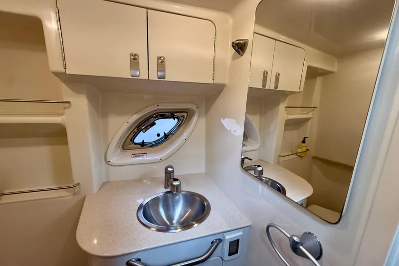 Flip Side Yacht Photos Pics 2010 Sea Ray 330 Sundancer bathroom with sink, mirror, and storage cabinets.