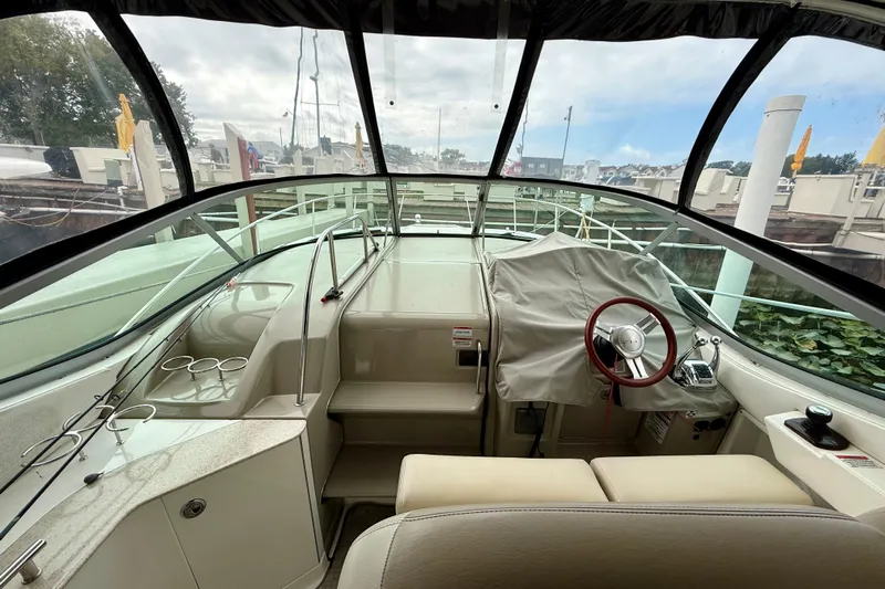 Flip Side Yacht Photos Pics Interior view of 2010 Sea Ray 330 Sundancer boat cockpit with covered steering wheel.