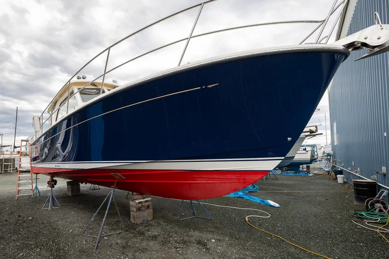 Power Play Yacht Photos Pics 2014 Sabre 38 Salon Express boat on dry dock, blue hull, red bottom, overcast sky.
