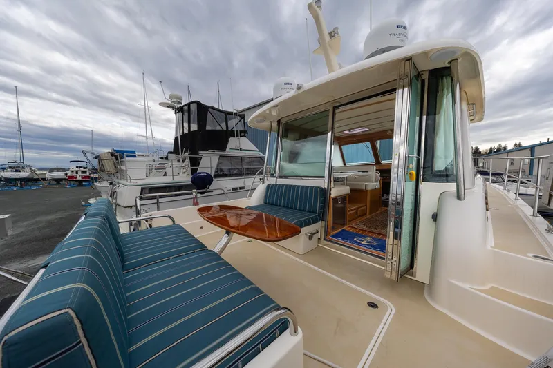 Power Play Yacht Photos Pics 2014 Sabre 38 Salon Express yacht with outdoor seating and table, docked under cloudy skies.