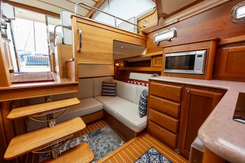 Power Play Yacht Photos Pics 2014 Sabre 38 Salon Express interior with wooden cabinetry, cozy seating, and modern appliances.