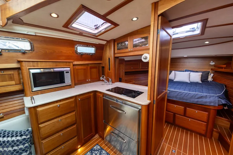 Power Play Yacht Photos Pics 2014 Sabre 38 Salon Express interior with wood cabinetry, kitchen, and cozy sleeping area.