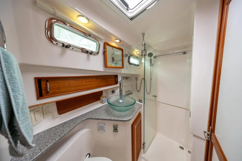 Power Play Yacht Photos Pics 2014 Sabre 38 Salon Express bathroom with glass sink, shower, and porthole windows.