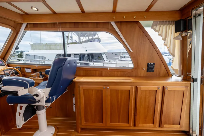 Power Play Yacht Photos Pics Interior of 2014 Sabre 38 Salon Express with wooden cabinetry and blue captain's chair.