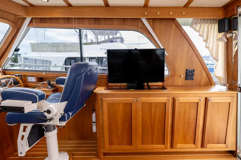 Power Play Yacht Photos Pics Interior of 2014 Sabre 38 Salon Express with wooden cabinetry and blue captain's chair.