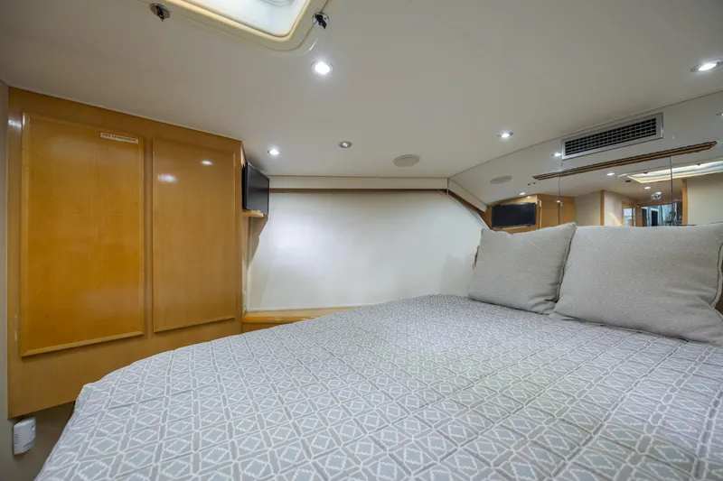  Yacht Photos Pics Interior of 2000 Hatteras 50 Convertible yacht, featuring a cozy bedroom with modern amenities.