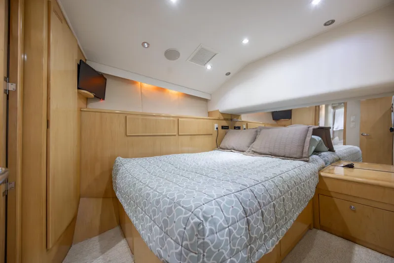  Yacht Photos Pics Luxurious bedroom interior of 2000 Hatteras 50 Convertible yacht with modern amenities.