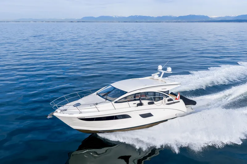  Yacht Photos Pics 2016 Sea Ray Sundancer 400 yacht cruising on open water with mountains in background.