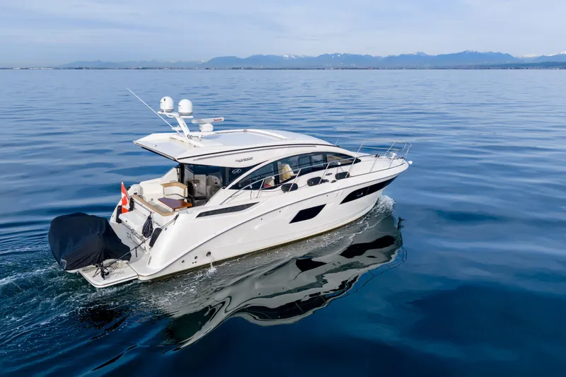  Yacht Photos Pics 2016 Sea Ray Sundancer 400 yacht cruising on calm waters with mountain backdrop.