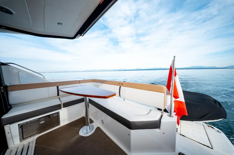  Yacht Photos Pics 2016 Sea Ray Sundancer 400 yacht deck with seating, table, and Canadian flag on calm water.