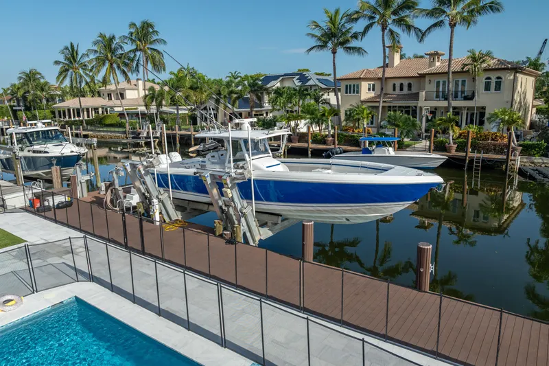 Chasing Chari Yacht Photos Pics 2016 Intrepid 400 Center Console boat docked by waterfront homes and palm trees.