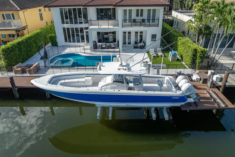 Chasing Chari Yacht Photos Pics 2016 Intrepid 400 Center Console boat docked by a luxurious waterfront home.
