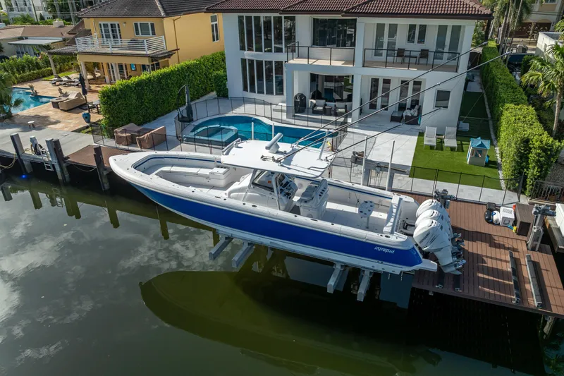 Chasing Chari Yacht Photos Pics A 2016 Intrepid 400 Center Console boat docked by a luxurious waterfront home.
