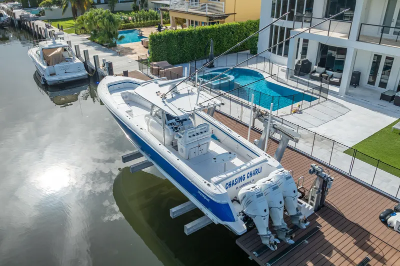 Chasing Chari Yacht Photos Pics 2016 Intrepid 400 Center Console boat docked by a modern waterfront home.