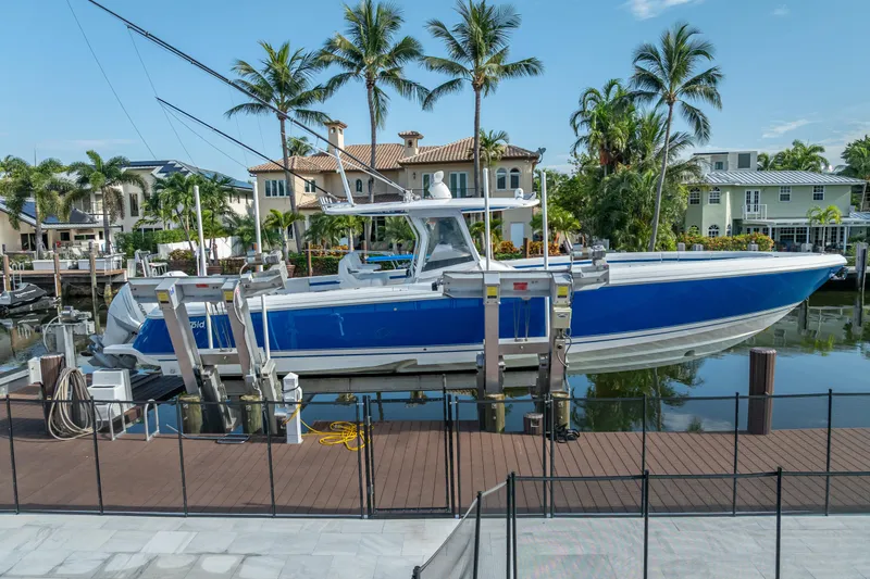 Chasing Chari Yacht Photos Pics 2016 Intrepid 400 Center Console boat docked near waterfront homes and palm trees.