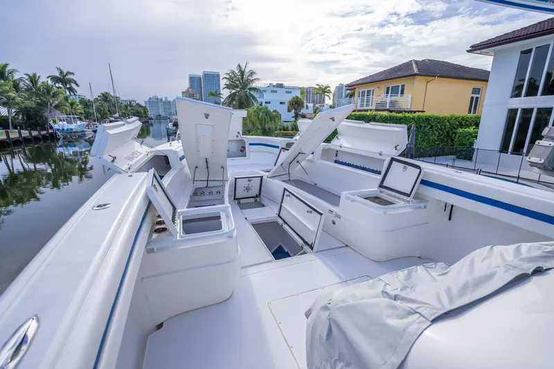 Chasing Chari Yacht Photos Pics 2016 Intrepid 400 Center Console boat with open storage compartments, docked by waterfront homes.