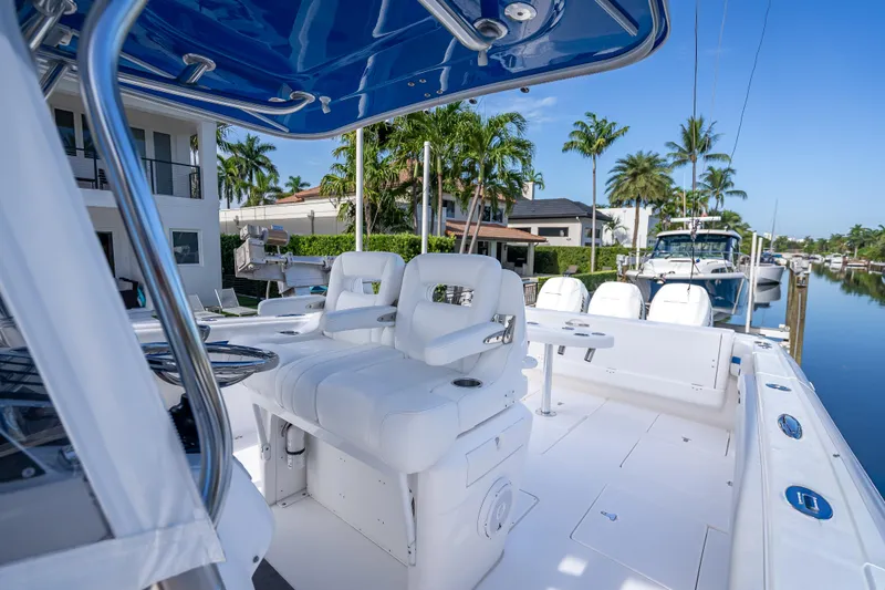 Chasing Chari Yacht Photos Pics 2016 Intrepid 400 Center Console boat with white seating, docked near waterfront homes.