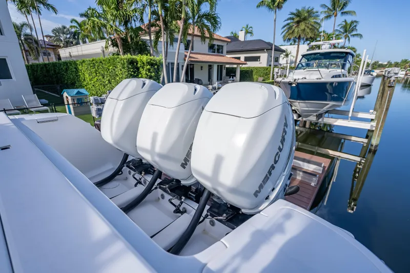 Chasing Chari Yacht Photos Pics 2016 Intrepid 400 Center Console with triple Mercury outboard engines docked by waterfront homes.