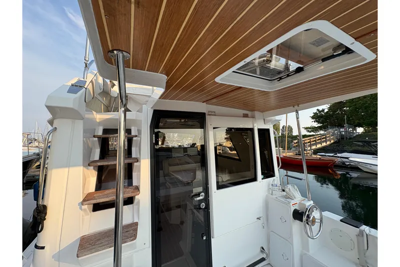 Miller Time Yacht Photos Pics 2018 Cutwater C-30 CB boat interior with wooden ceiling and staircase, docked by the water.