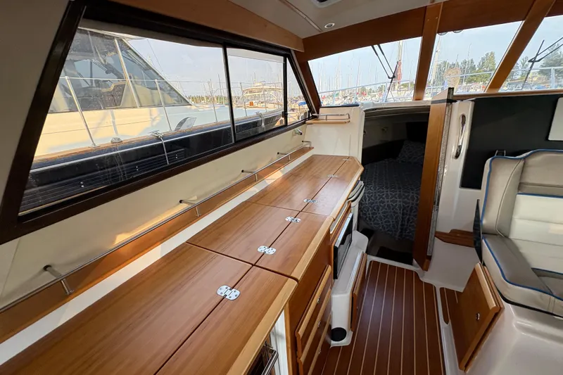 Miller Time Yacht Photos Pics 2018 Cutwater C-30 CB interior with wood cabinetry and seating, docked at marina.