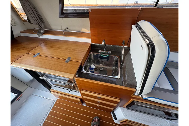 Miller Time Yacht Photos Pics 2018 Cutwater C-30 CB boat interior with wooden cabinetry and compact kitchen sink.