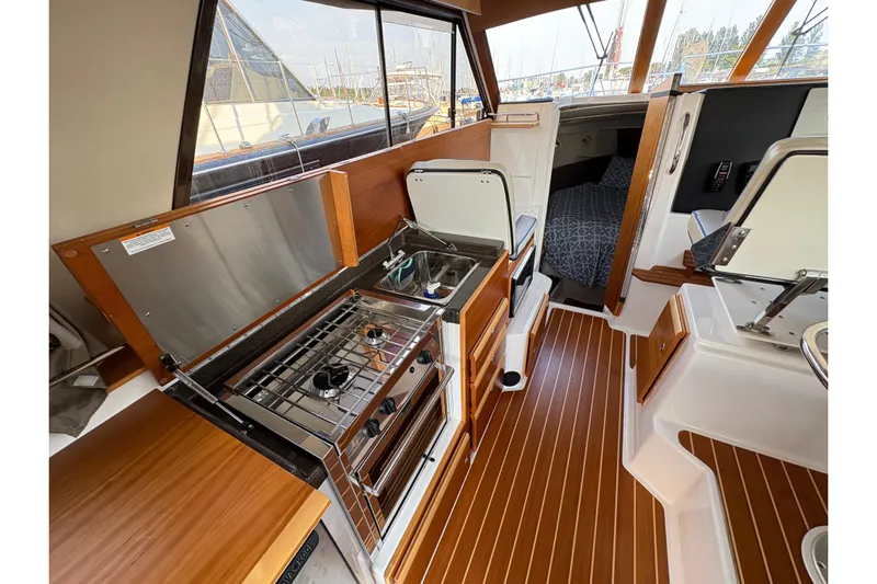 Miller Time Yacht Photos Pics 2018 Cutwater C-30 CB interior with kitchenette, stove, sink, and cozy cabin area.