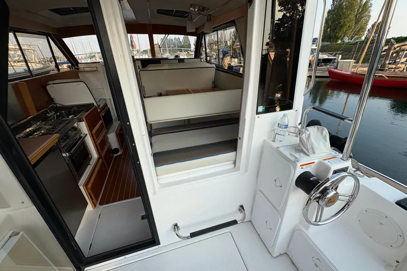 Miller Time Yacht Photos Pics 2018 Cutwater C-30 CB boat interior with kitchen and seating area, docked by the water.