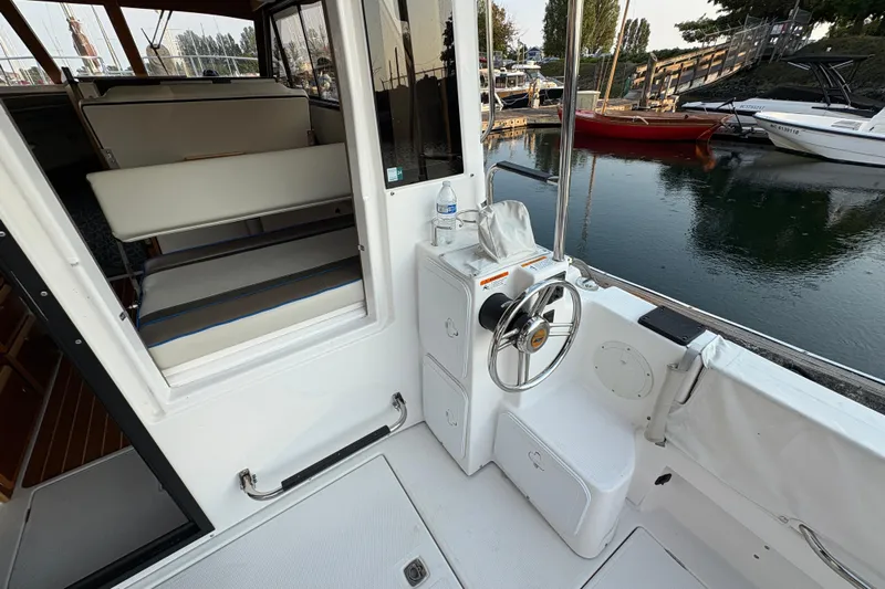 Miller Time Yacht Photos Pics 2018 Cutwater C-30 CB boat interior with steering wheel and seating, docked by the water.
