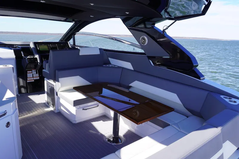  Yacht Photos Pics 2023 Cruisers Yachts 42 GLS OB interior with sleek seating and table, overlooking the ocean.